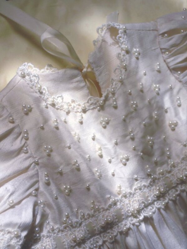 Close-up of hand-sewn pearl embellishments on christening gown bodice — French couture stitching, Kingdom Gowns Michigan